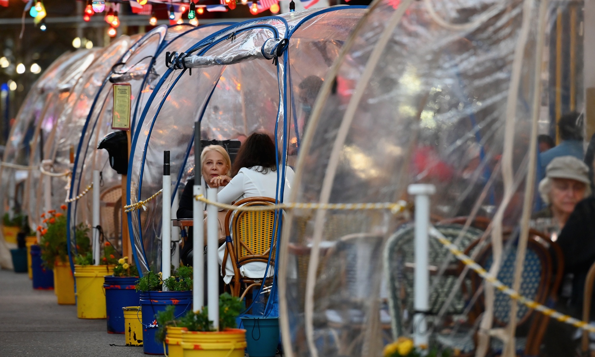 People dine in plastic tents at a restaurant in Manhattan in New York City amid the coronavirus pandemic