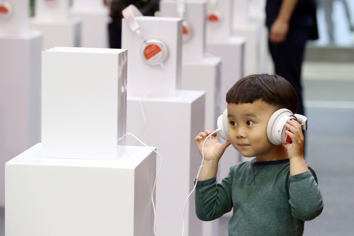 A child tries out an audio book at a Ximalaya booth during a book fair in Shenzhen
